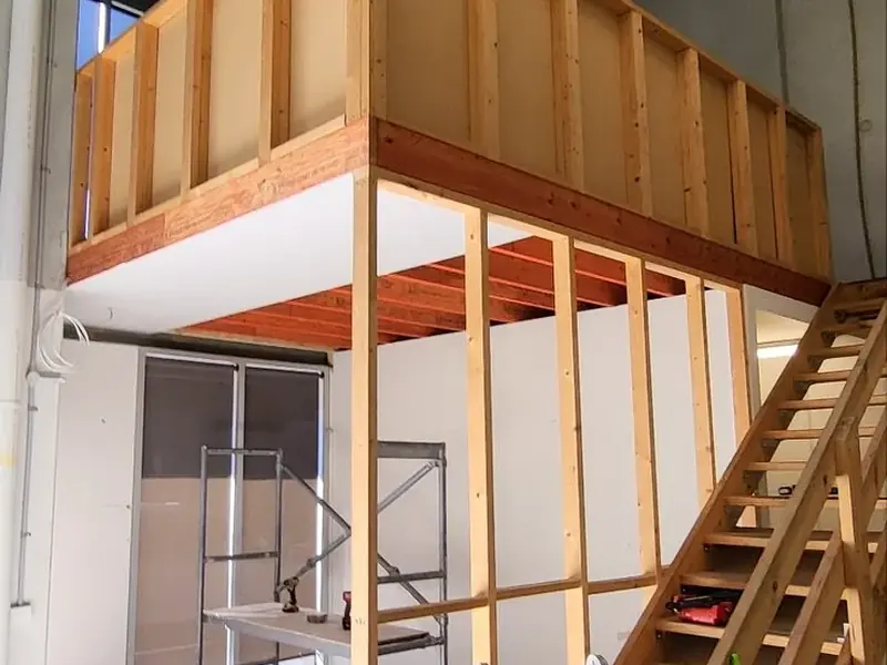 Commercial office and mezzanine under construction with framed walls and internal stairs