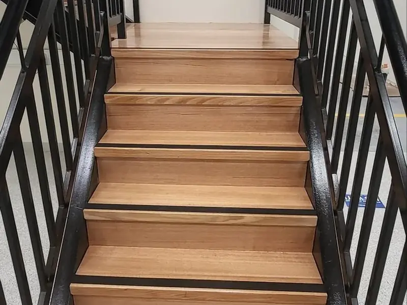 Finished timber staircase with handrail inside a commercial property